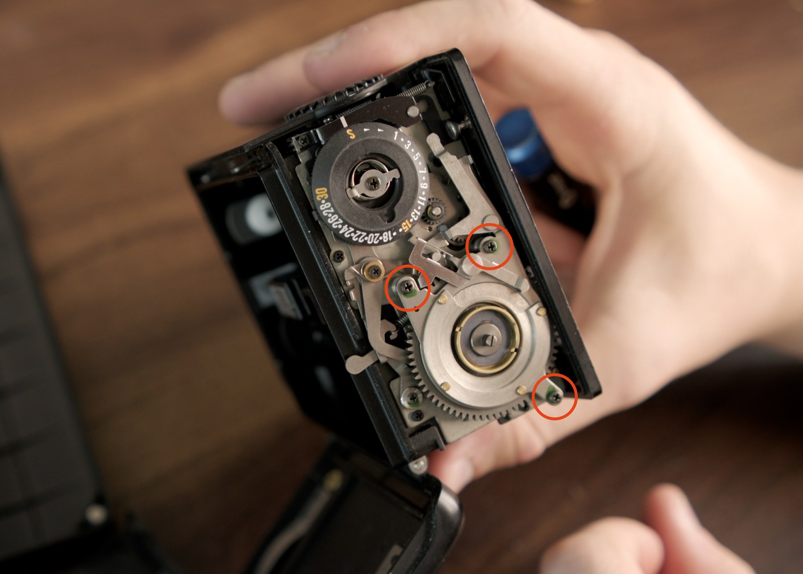 Open Mamiya 645 Pro back showing the three screws around the frame spacing assembly cover.