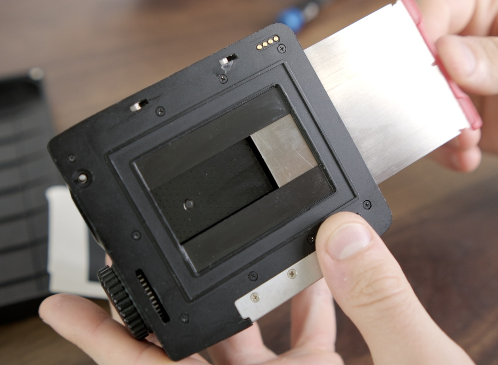 Darkslide being inserted through the reinstalled front panel.