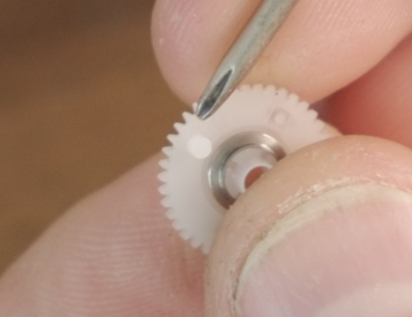 Close-up of the plastic gear tab used for alignment while restacking the frame spacing assembly.