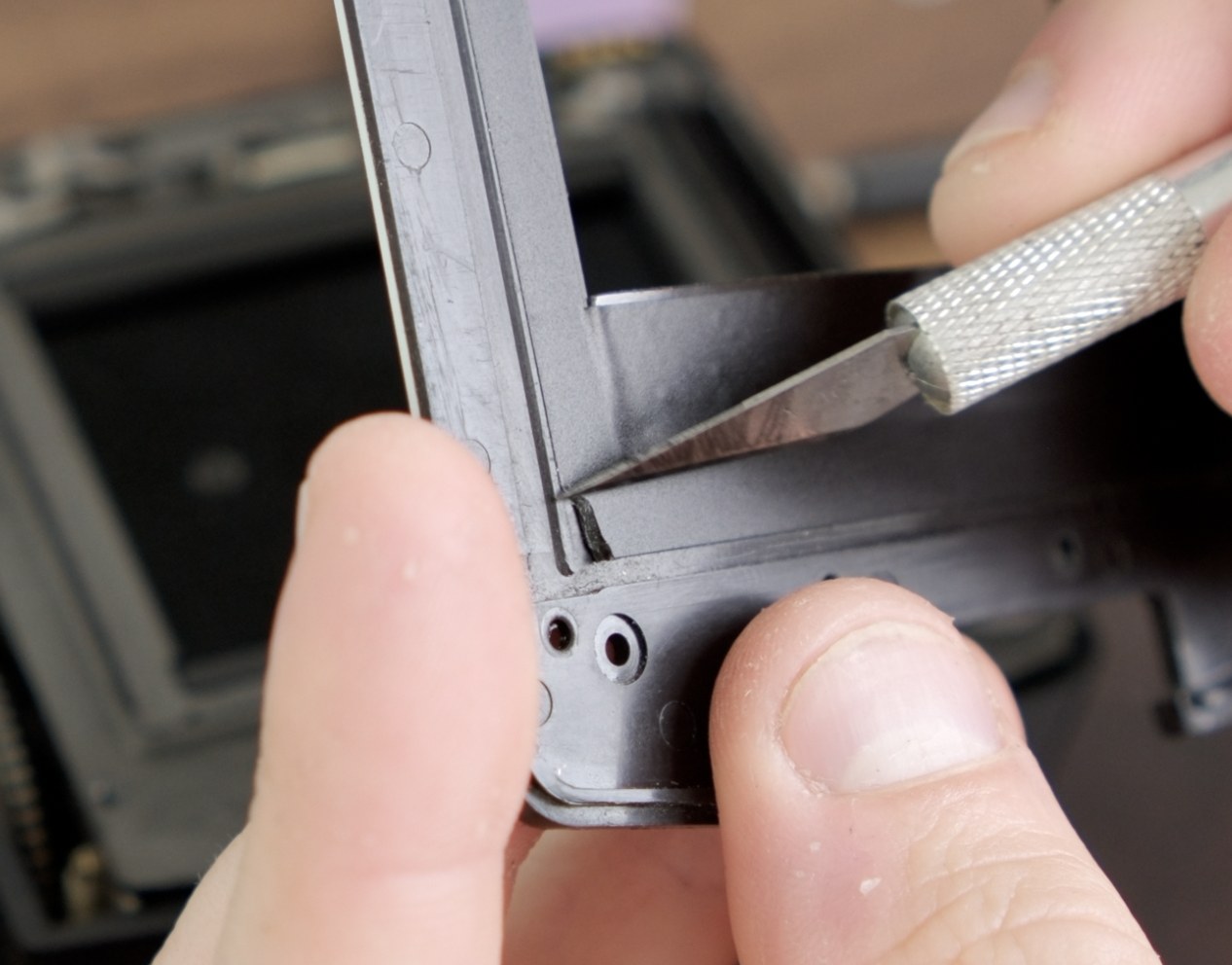 Raised vinyl edge being trimmed with an X-Acto knife near the darkslide path.